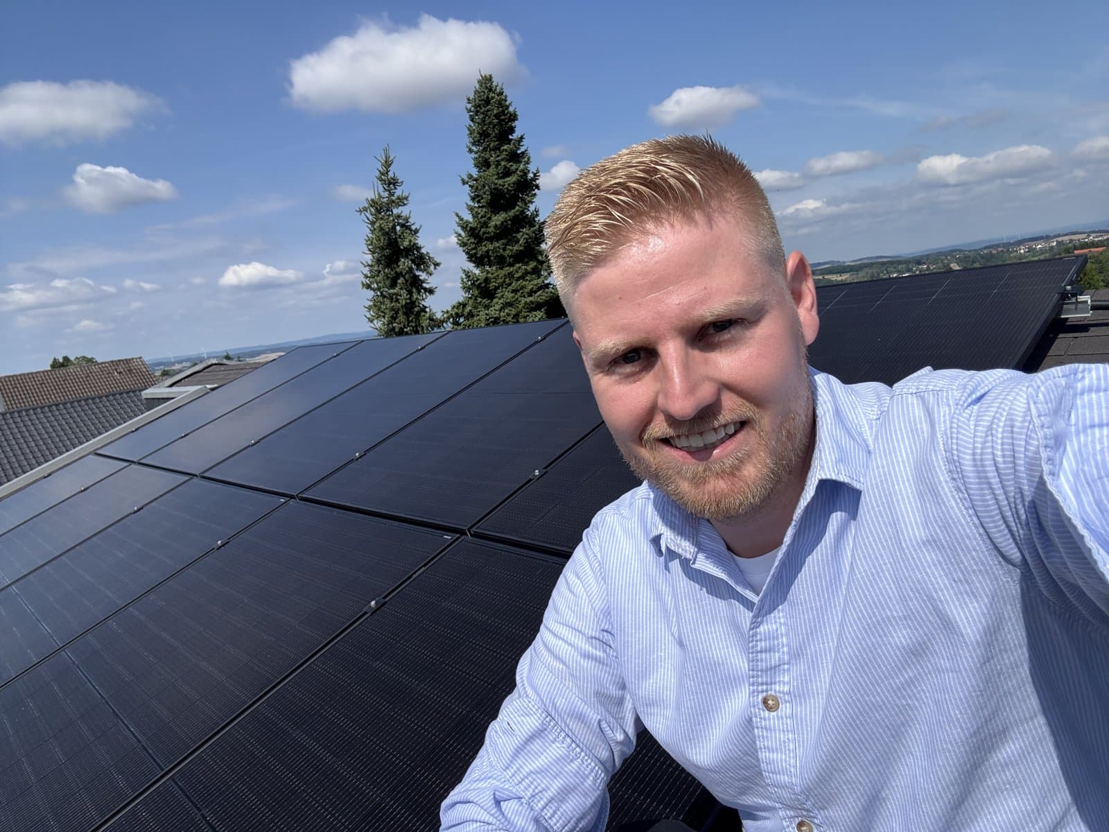 Fabian Kulla auf einem Dach mit frisch installierter Photovoltaikanlage